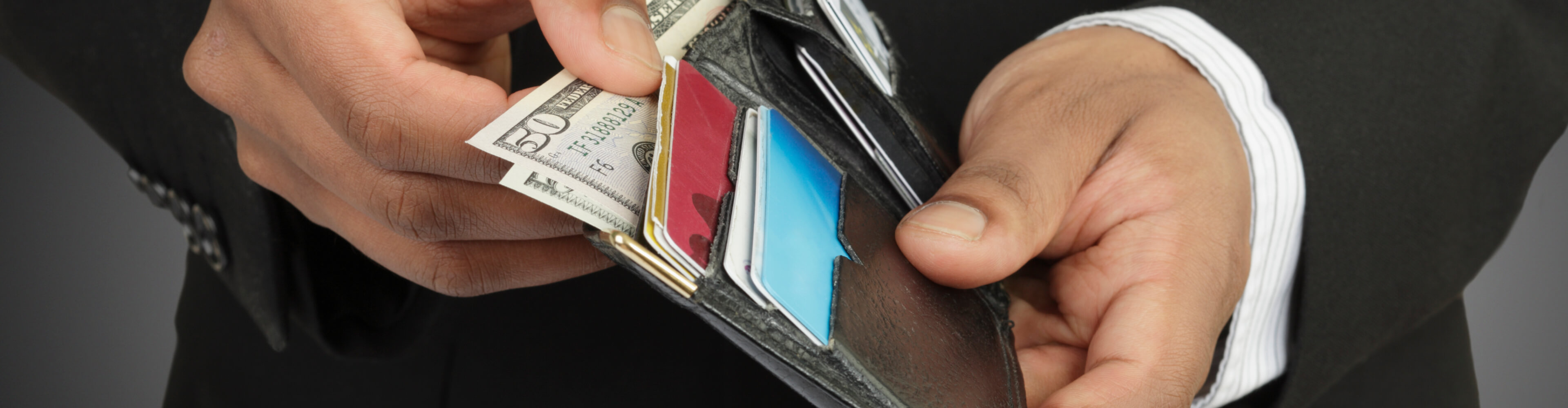 A man searching through his wallet to make sure he hasn't lost anything.